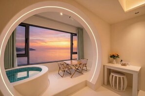 A room with a view of the sea at sunset, a small pool, a table with chairs, and a desk with a stool. - Xunliao Bay Yijing Holiday Sea-view Hotel (Huidong)
