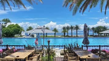 Zona junto a la piscina con mobiliario exterior y vistas al agua.