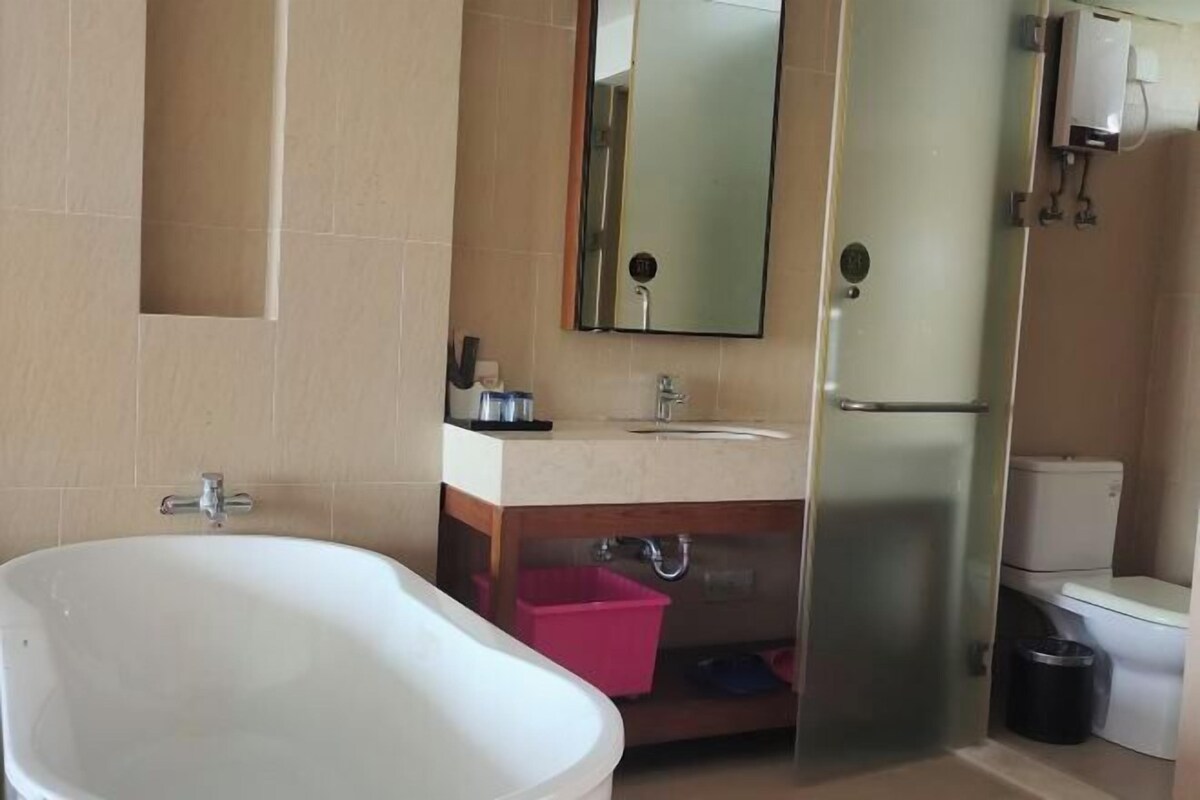 A bathroom with a bathtub, sink, mirror, and toilet.