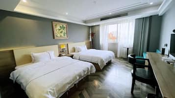A hotel room with two beds, a desk, and a chair.