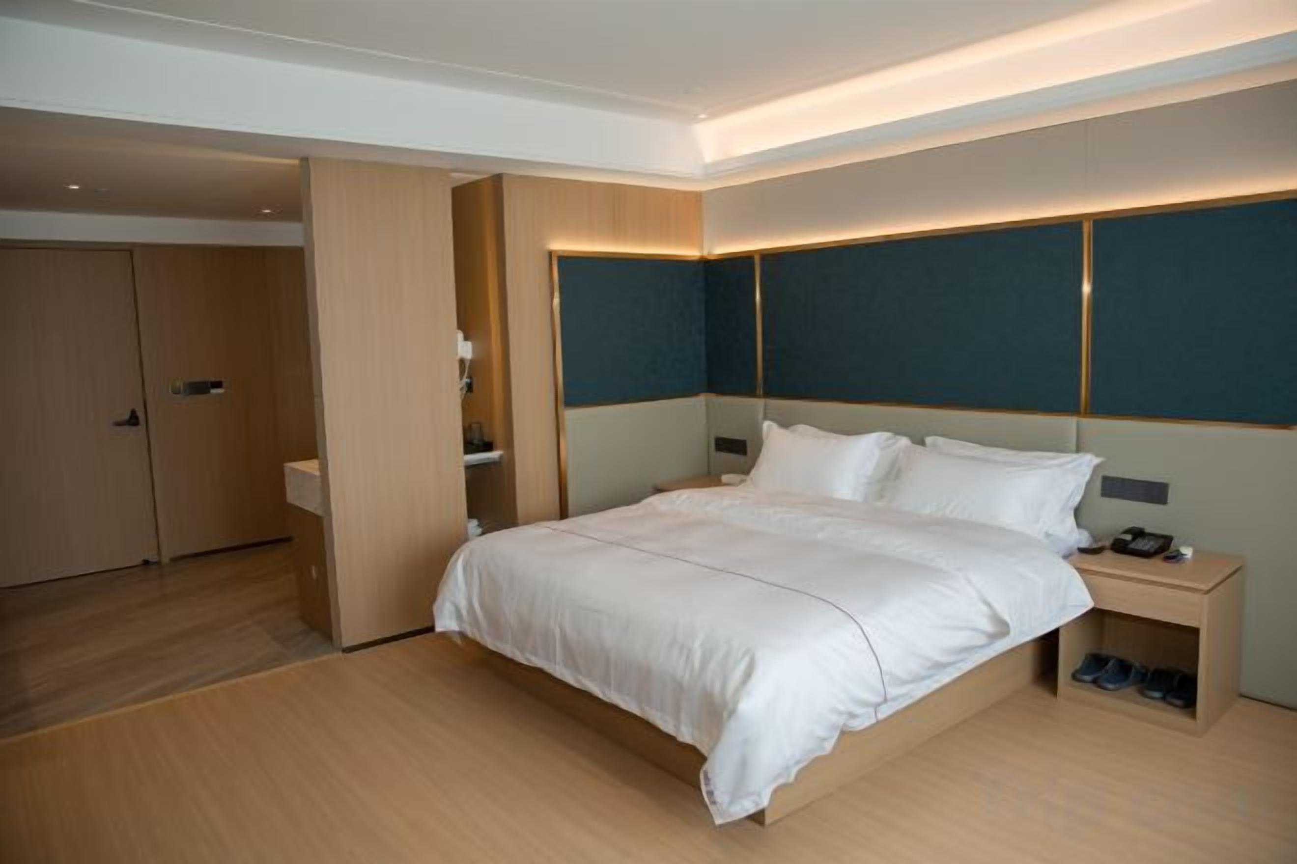 Una camera d'albergo con un letto grande, un comodino e un armadio.