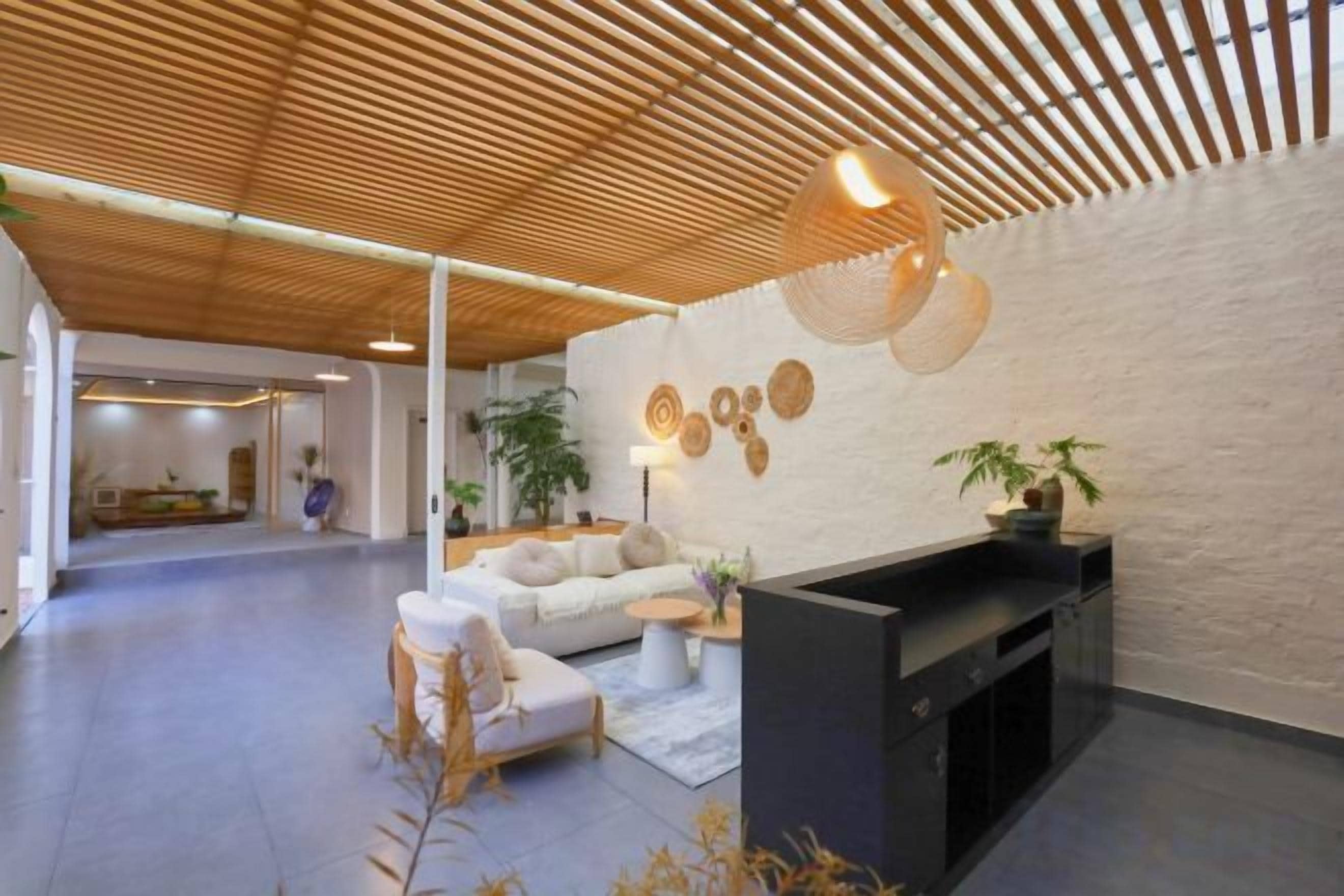 Un interior moderno con una recepción, una zona de estar y una chimenea.