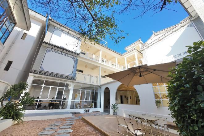 Un patio de varios niveles con asientos al aire libre, un área cubierta y una escalera.