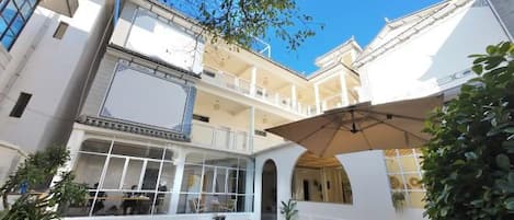 A multi-level courtyard with outdoor seating, a covered area, and a staircase.