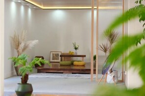 A room with a wooden bench, a small table, and a potted plant. - Dali Mengyunqi Inn (Dali City)