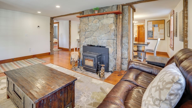 A living room with a stone fireplace, a leather sofa, and a wooden coffee table. - Walk to Memorial Park: Pet-Friendly Bethlehem Home (Bethlehem)