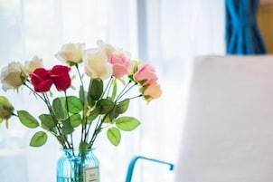 Un jarrón con diversas rosas sobre una mesa.