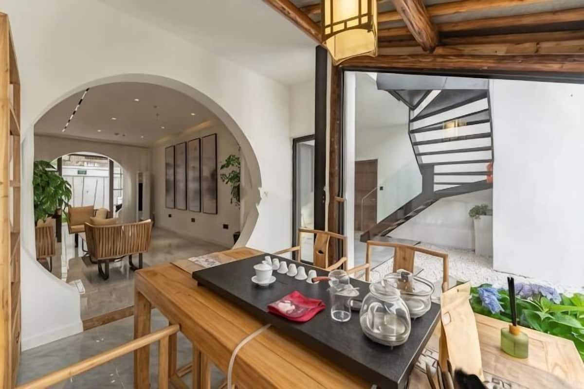 Un interior moderno con una mesa de madera, sillas y una escalera.