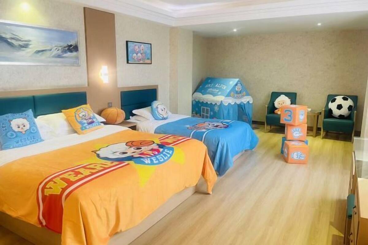 Une chambre d’hôtel avec deux lits, un espace de jeux et une vue sur la plage.