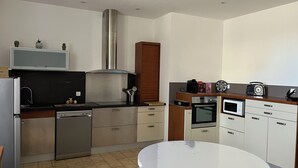 A modern kitchen with stainless steel appliances, wooden cabinets, and a central island.