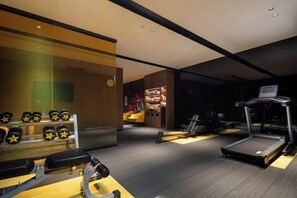 A gym with treadmills, weights, and a mirror. - Hampton by Hilton Xuzhou Huaihai Road (Xuzhou)