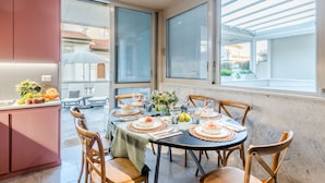 Comedor con una mesa redonda dispuesta para cuatro personas, rodeado de sillas de madera.