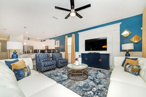 Relax in this stylish living room with a sofa, coffee table, and large flat-screen TV.