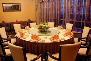 Una mesa de comedor redonda con sillas, un centro de mesa y un juego de comedor.