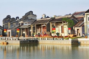 Una hilera de edificios de estilo tradicional con una extensión acuática reflectante al frente.