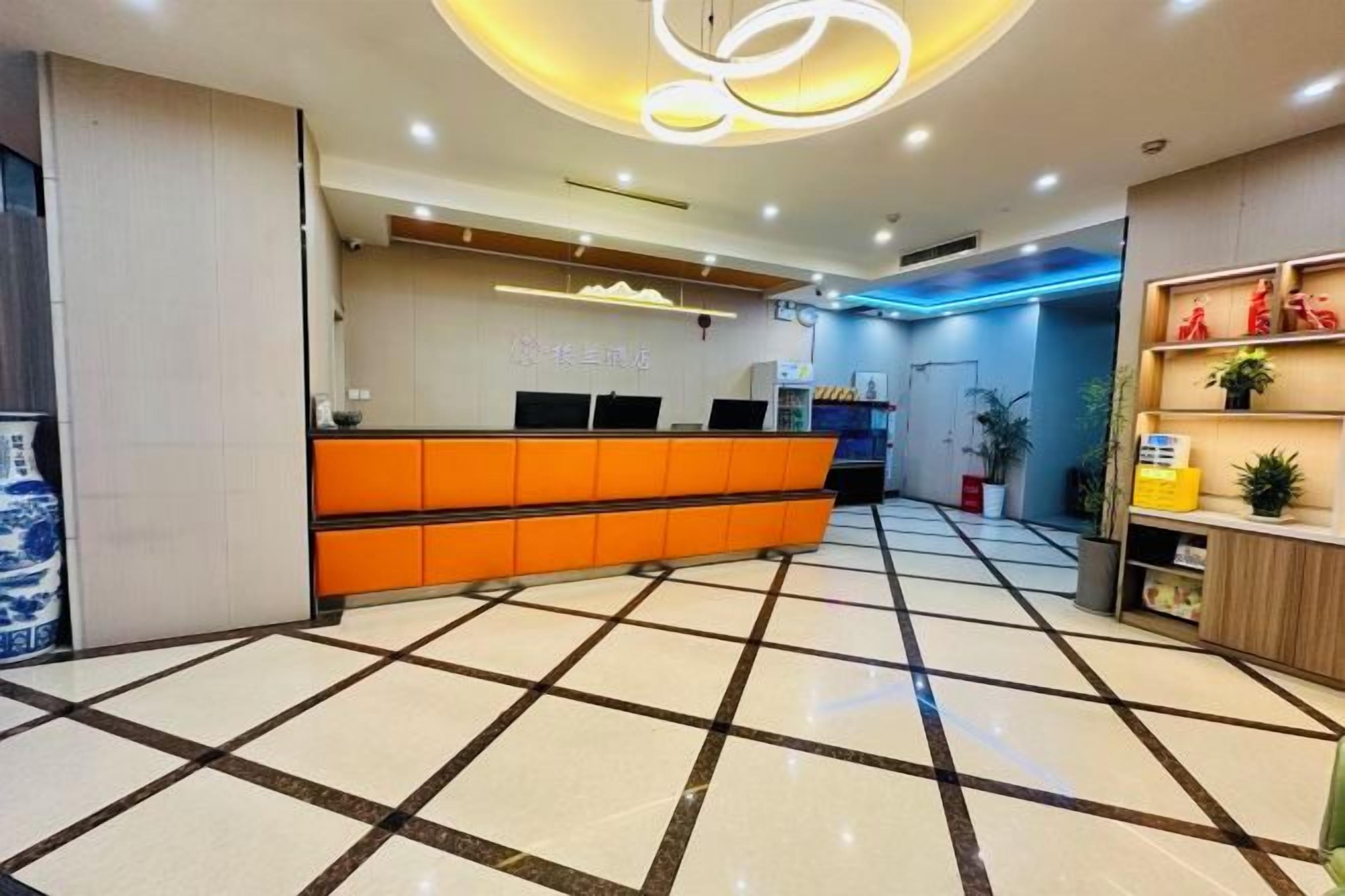 A reception area with a check-in counter, a tiled floor, and a ceiling with recessed lighting.