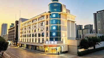 Un hotel de diseño moderno, con varios pisos y una destacada torre en esquina.