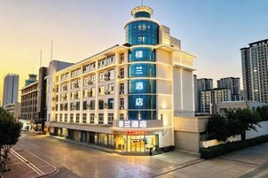 Un hotel de diseño moderno, con varios pisos y una destacada torre en esquina.
