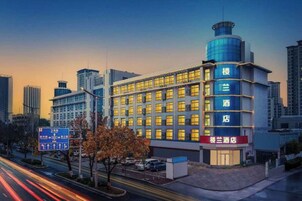 Un hotel de varios pisos, con una entrada destacada en esquina y un diseño arquitectónico moderno.