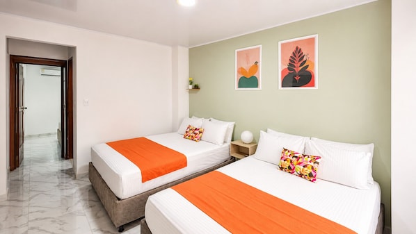 Une chambre d’hôtel avec deux lits, un sol en marbre et des œuvres d’art accrochées au mur.
