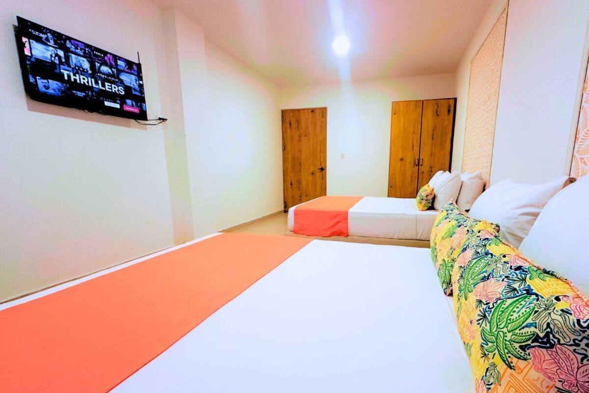 Une chambre d’hôtel avec un lit, un téléviseur fixé au mur et une armoire en bois.