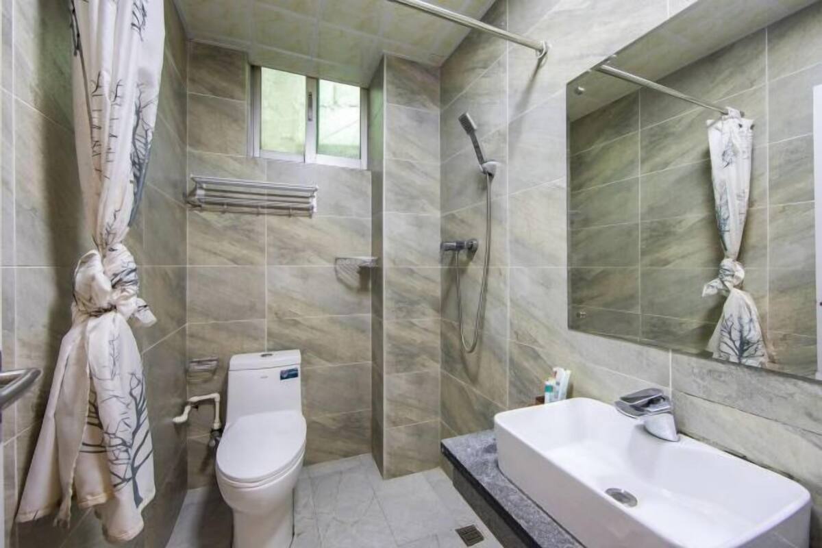 A bathroom with a shower, toilet, and bathtub.
