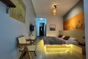 Un dormitorio moderno con cama, mesita de noche y una silla.