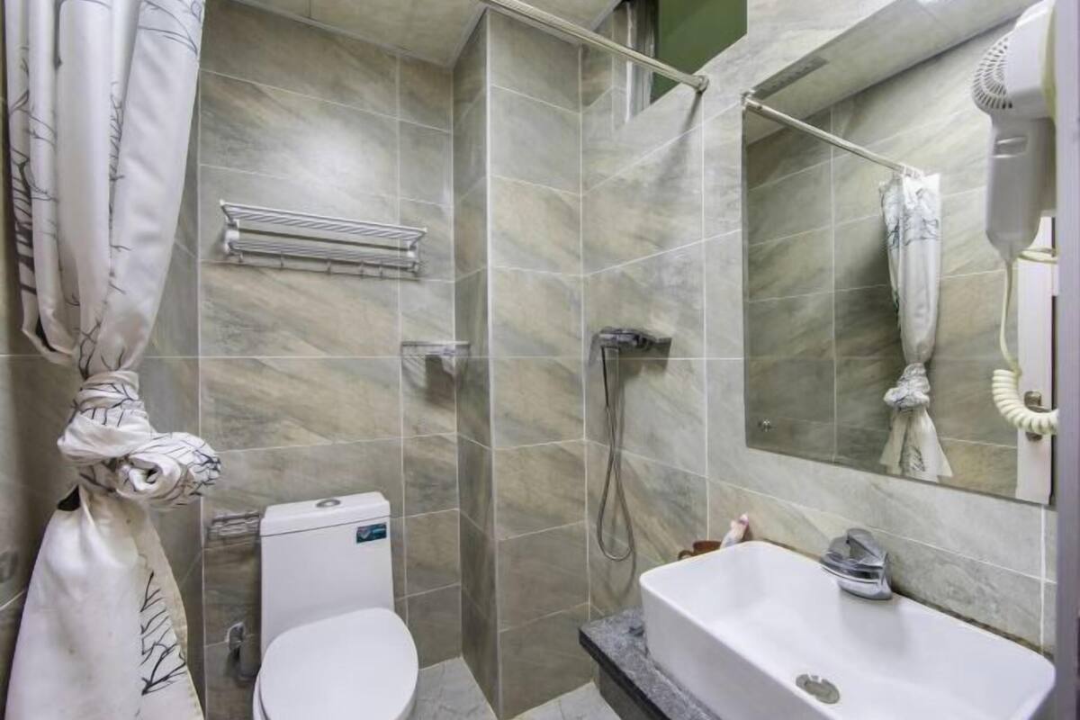 A bathroom with a toilet, shower, and sink.
