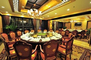A conference room with a round table, chairs, and a chandelier.