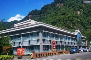 A building with a traditional architectural style, featuring multiple windows and a prominent entrance. - Simianshan Hotel (Chongqing)