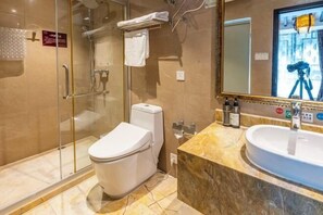 A modern bathroom with a glass-enclosed shower, a white toilet, a marble countertop, and a large mirror. - Simianshan Hotel (Chongqing)