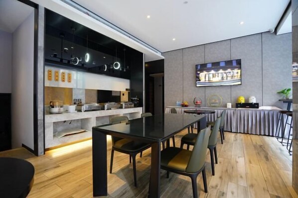 A modern dining area with a glass partition separating the kitchen from the dining space. - Ruidu Business Hotel (Wenzhou)