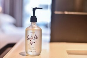 A bottle of QianNa liquid soap on a wooden surface. - Ruidu Business Hotel (Wenzhou)