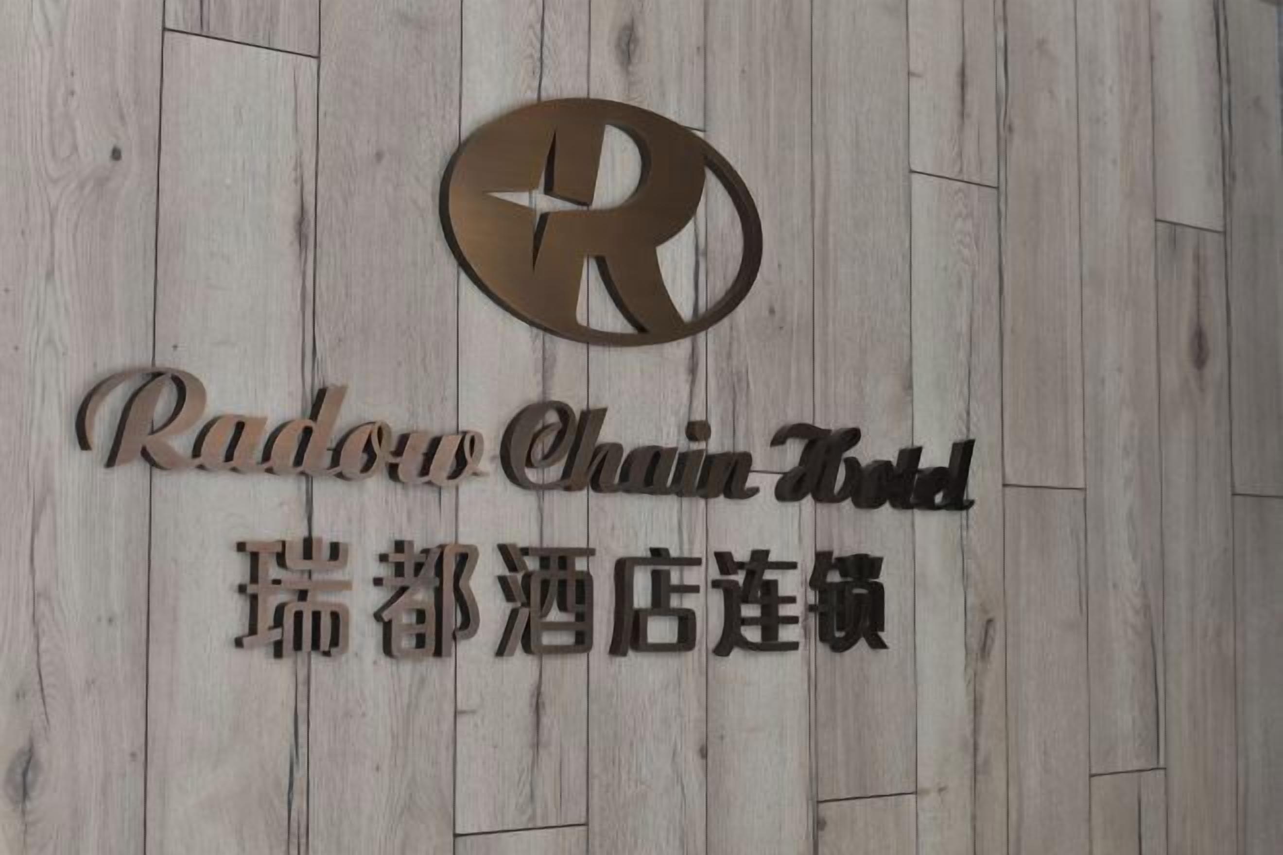 Eine Holzwand mit einem Logo und dem Text, der das Radon Chain Hotel angibt.
