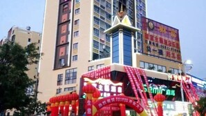Un hotel con un llamativo letrero rojo y blanco, amplias ventanas y un restaurante visible llamado "Semic".