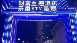 Un letrero de neón con caracteres chinos que indica un hotel.