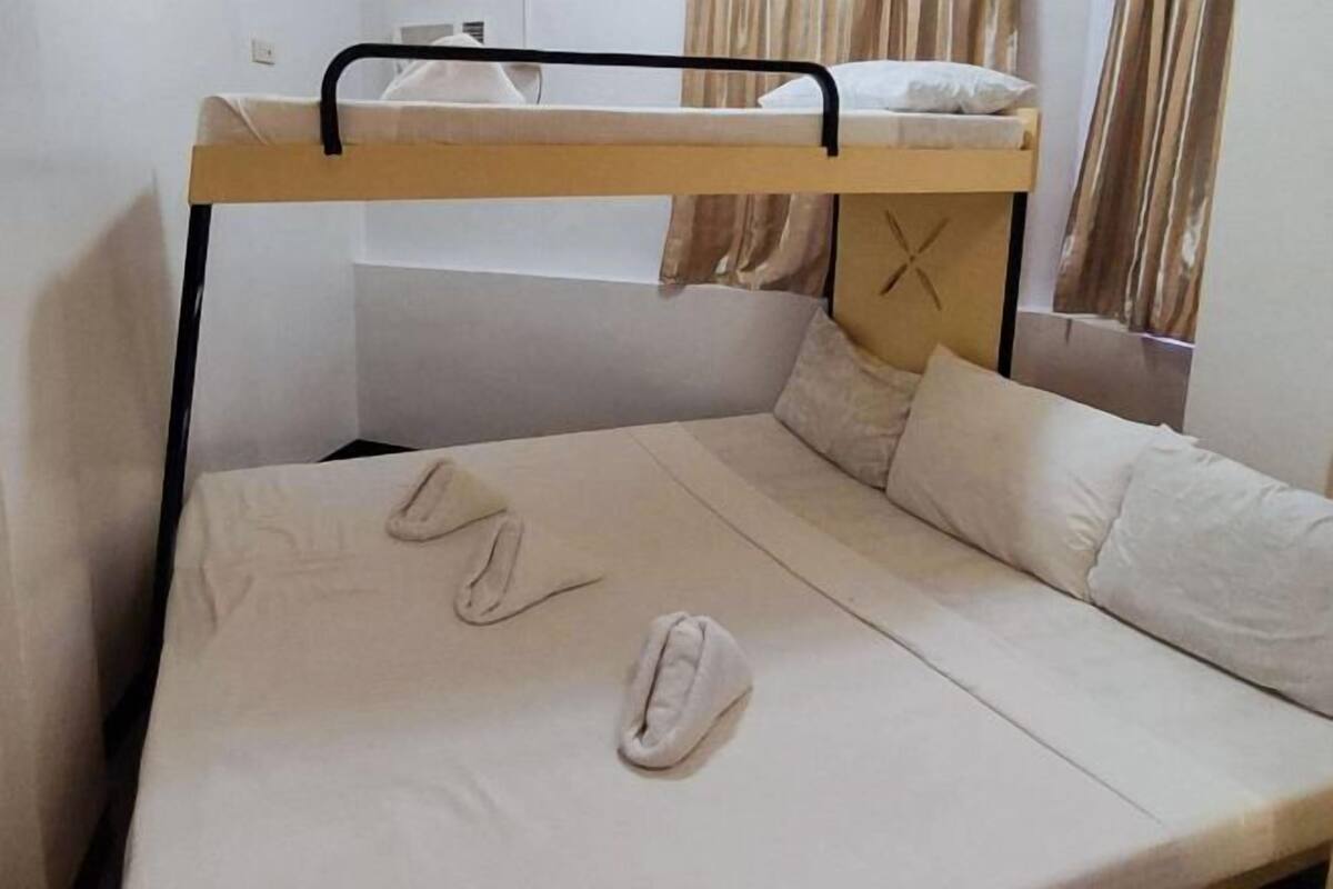 Una cama litera con estructura de madera y ropa de cama blanca.