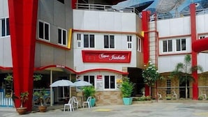 A multi-story building with a prominent red and white facade, a sign for 'Casa Isabelle', and satellite dishes on the roof.