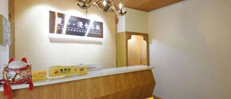 A reception desk with a wooden counter and a sign above it.