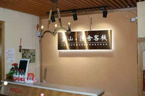 A reception desk with a sign above it, a chandelier, and a wooden ceiling. - Changsha Lushan Manshe Inn (Changsha)