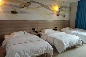 Habitación de hotel con dos camas, cabecero de madera, una obra de arte en la pared y una cortina azul.