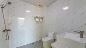 A bathroom with a white marble wall, a toilet, a sink, and a shower. - Fogang Bolin Fashion Hotel (Fogang)