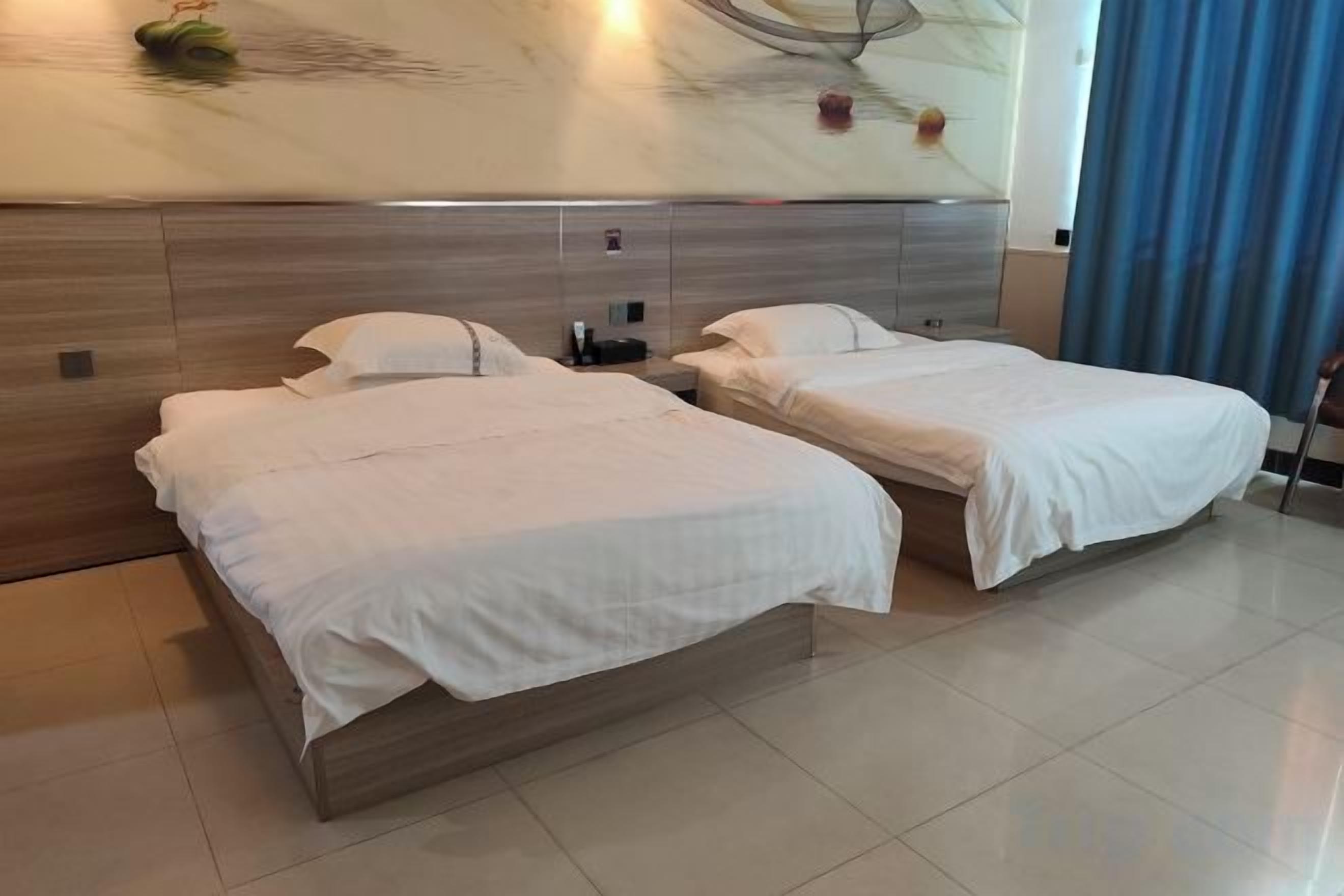 Habitación de hotel con dos camas, una obra de arte grande en la pared y vistas al exterior.