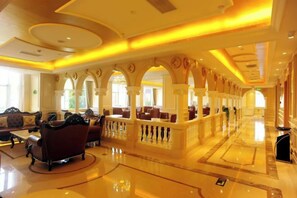 A spacious lobby with a central seating area, a reception desk, and a series of arches.
