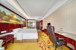 A hotel room with a bed, a desk, a chair, a television, and a painting on the wall. - Vienna Hotel (Hangzhou Xiaoshan Airport) (Hangzhou)