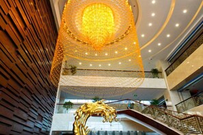 Un atrium à plusieurs niveaux, doté d’une structure décorative centrale, de nombreux étages et d’un escalier.