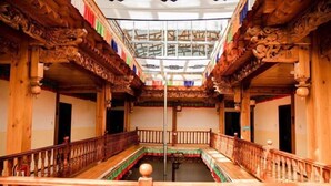 A traditional wooden building with intricate carvings and a central open space.