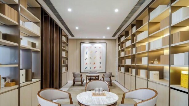 Una habitación con una mesa redonda, cuatro sillas y estanterías a ambos lados.