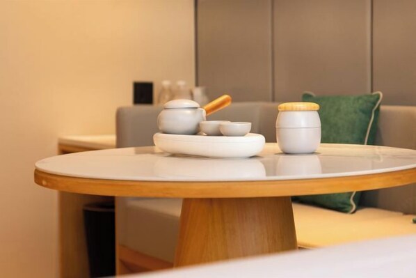 A round wooden table with a white surface, a white teapot, a white cup, and a white container with a wooden lid. - Xincheng Hotel (Xi'an Mingguang Road Bachengmen Subway Station) (Xi'an)