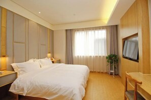 A hotel room with a large bed, a TV mounted on the wall, a bedside table with a lamp, and a window with curtains. - Xincheng Hotel (Xi'an Mingguang Road Bachengmen Subway Station) (Xi'an)